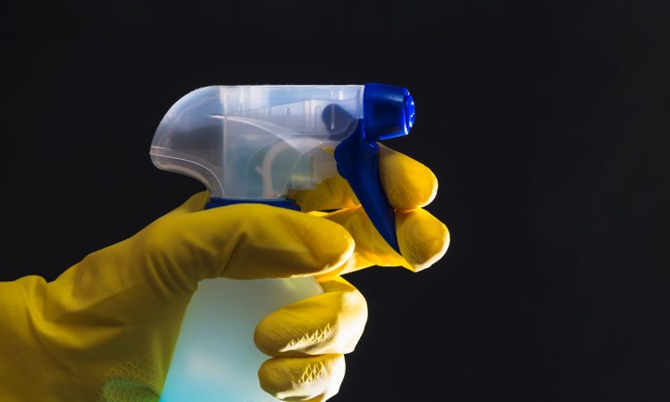 janitor-s-hand-with-yellow-gloves-holding-spray-bottle